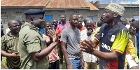 An unidentified man confronts a police officer in Sofia A village, Busia town, following delays