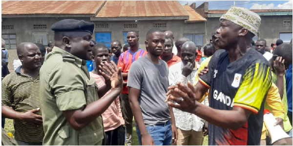An unidentified man confronts a police officer in Sofia A village, Busia town, following delays