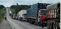 Trucks wait in a line on the road to enter Uganda at the Malaba border with Kenya