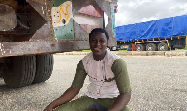 Badamasi Mohammed, a freight truck driver sits beside his truck at the Jibiya border between Nigeria