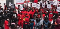 Some Democracy Hub protestors clad in red attire and carrying placards