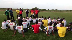 Black Stars B players listening to the coaches