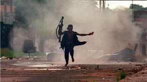 A fighter runs from an explosion in Monrovia in 1996 during the Liberian civil war
