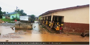 Pupils on the corridor of the school block waiting to cross to another side of the compound