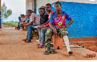 Wilondja Mukula, a member of the Wazalendo militia sits with other patients after the treatment