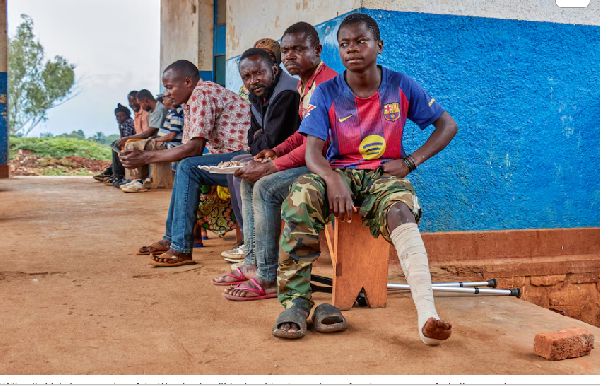 Wilondja Mukula, a member of the Wazalendo militia sits with other patients after the treatment