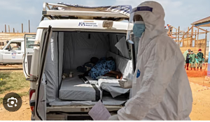 A paramedic stands by a suspected Ebola patient lying in an ambulance at a treatment center in Bunia