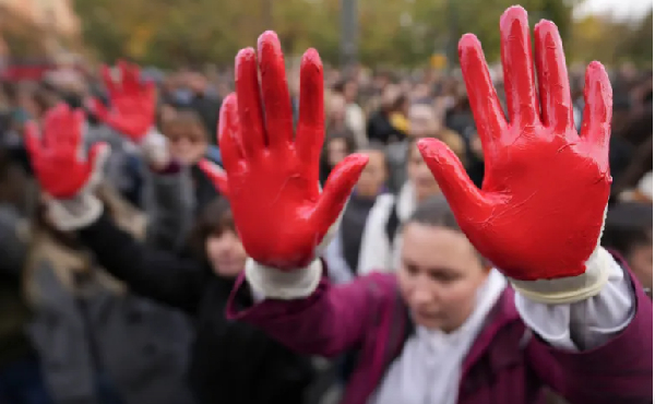 Protesters with red paint on their hands, symbolising blood, demanded arrests