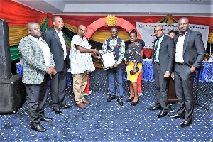 Mr Seth Hammond, Administration Manager of Agro Ecom Ghana (middle) receiving the award