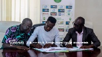 Godwin Okudzeto (middle) signing the contract. With him are some officials of the club