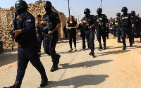 Jordanian police patrol near mourners at the funeral of victims of a Greek Orthodox church attack