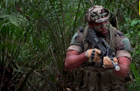 A soldier steps out of the forest in Gabon's Pongara National Park forest