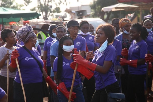 Some female staff of Jospong group cheerfully cleaning up the market