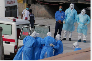 Health workers in protective gear evacuate patients from  MV Hondius cruise ship into an ambulance