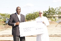 CEO of Dalex Finance, Mr. Ken Thompson presenting a cheque on the project to Rev. Father Campbell