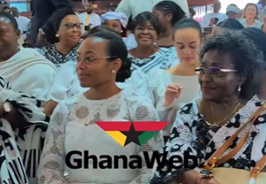 Dr  Zanetor Agyeman-Rawlings in all-white lace dress seated among family members