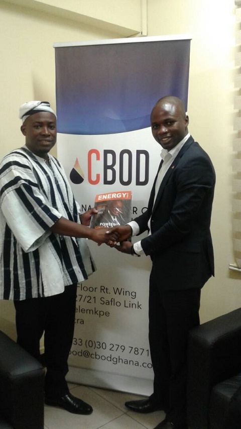 CEO of Energy Media Group (EMG), Henry Teinor presenting a magazine to Senyo Hosi of CBOD