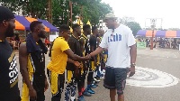 Didier Mbenga in a handshake with Marshalls players before their game