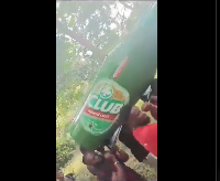 A screenshot of the people carrying the beer-shaped casket