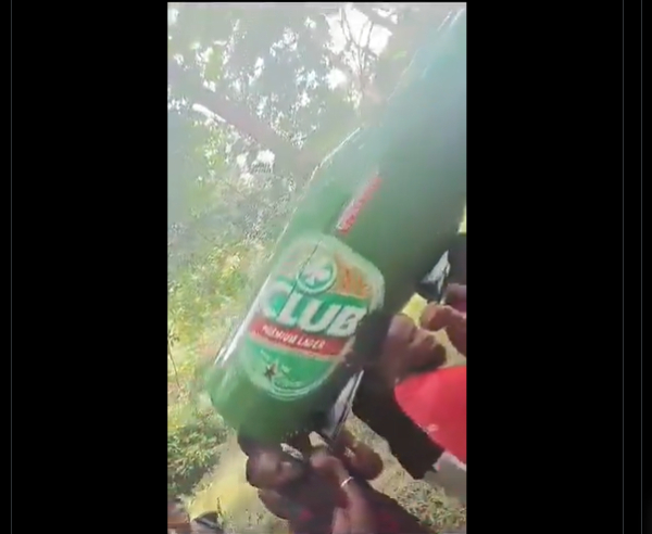 A screenshot of the people carrying the beer-shaped casket