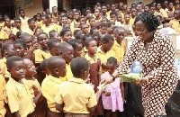 A representative from the foundation distributing chocolates to the school children