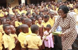 A representative from the foundation distributing chocolates to the school children