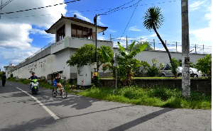 Motorists ride past the notorious Kerobokan prison where two of the 'Bali Nine' were being held