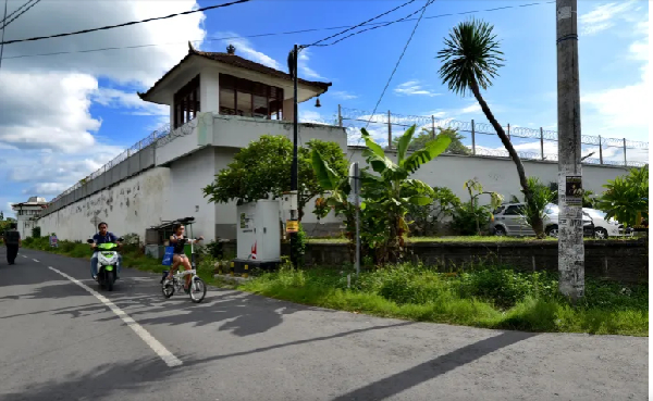 Motorists ride past the notorious Kerobokan prison where two of the 'Bali Nine' were being held