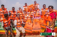 Samuel Okudzeto Ablakwa in a group picture with boat operators wearing life jackets
