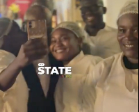 The female cook is seen here planting the kiss on the Akufo-Addo's cheek
