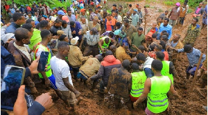 Residents dig to recover the dead body of a victim of the landslide