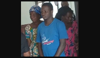 Newell Gavu (middle) being aided to court some family members