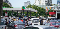 People are waiting in line to buy fuel at a Nigerian National Petroleum Company Limited gas station