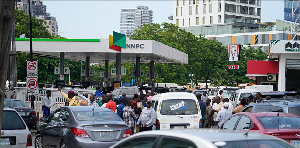 People are waiting in line to buy fuel at a Nigerian National Petroleum Company Limited gas station