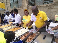 Volunteers dishing out food to the children
