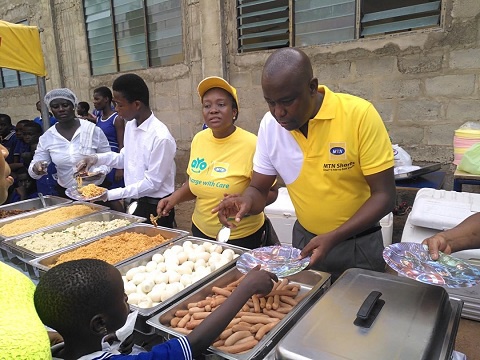 Volunteers dishing out food to the children