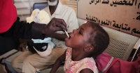 A Sudanese girl receives an oral cholera vaccine during a vaccination campaign