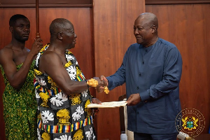 Asantehene Otumfuo Osei Tutu II (L) is presenting the report to President Mahama