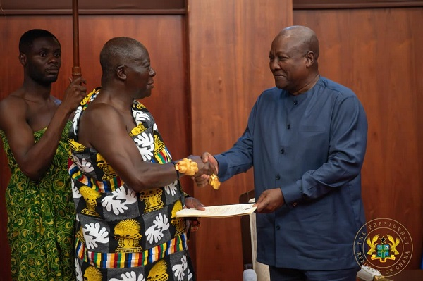 Asantehene Otumfuo Osei Tutu II (L) is presenting the report to President Mahama