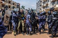 Demonstrators are detained by police after trying to reach the Ugandan Parliament during a protest