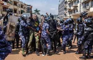 Demonstrators are detained by police after trying to reach the Ugandan Parliament during a protest