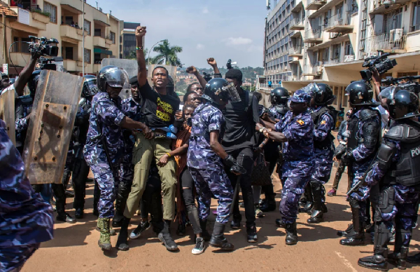 Demonstrators are detained by police after trying to reach the Ugandan Parliament during a protest