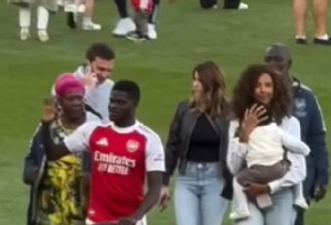 Thomas Partey (in red jersey) waving at Arsenal fans with his family at the Emirates Stadium
