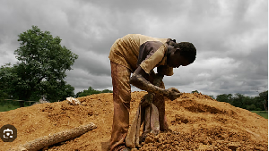 Mohammed Keita, 15, of Mali, checks mined earth for the presence of gold particles at a mine