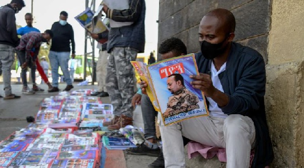 Ethiopians read newspapers reporting on the current military confrontation in the country