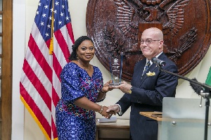 Outgoing U.S. Ambassador, Robert P. Jackson presenting an award to former EC Chair Charlotte Osei