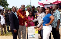 Officials presenting a table top fridge to a deserving worker