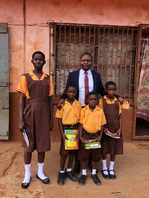 Mr Wisdom Dordoe, Founder of Give Me Hope Foundation in a photoshoot with some kids