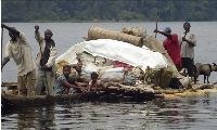 Congolese villagers cross the Ruki river on a small canoe in Balongo