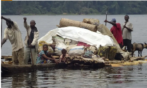 Congolese villagers cross the Ruki river on a small canoe in Balongo
